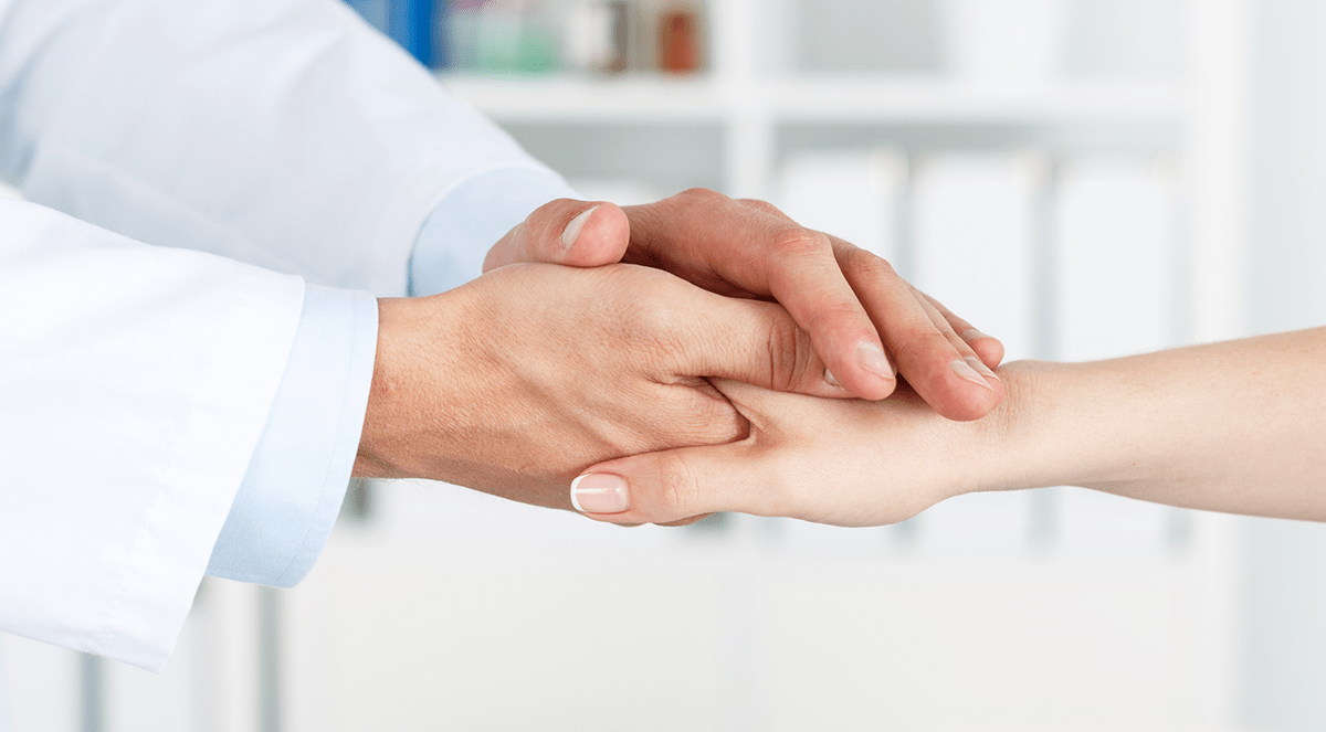 Caring doctor holding patient's hand